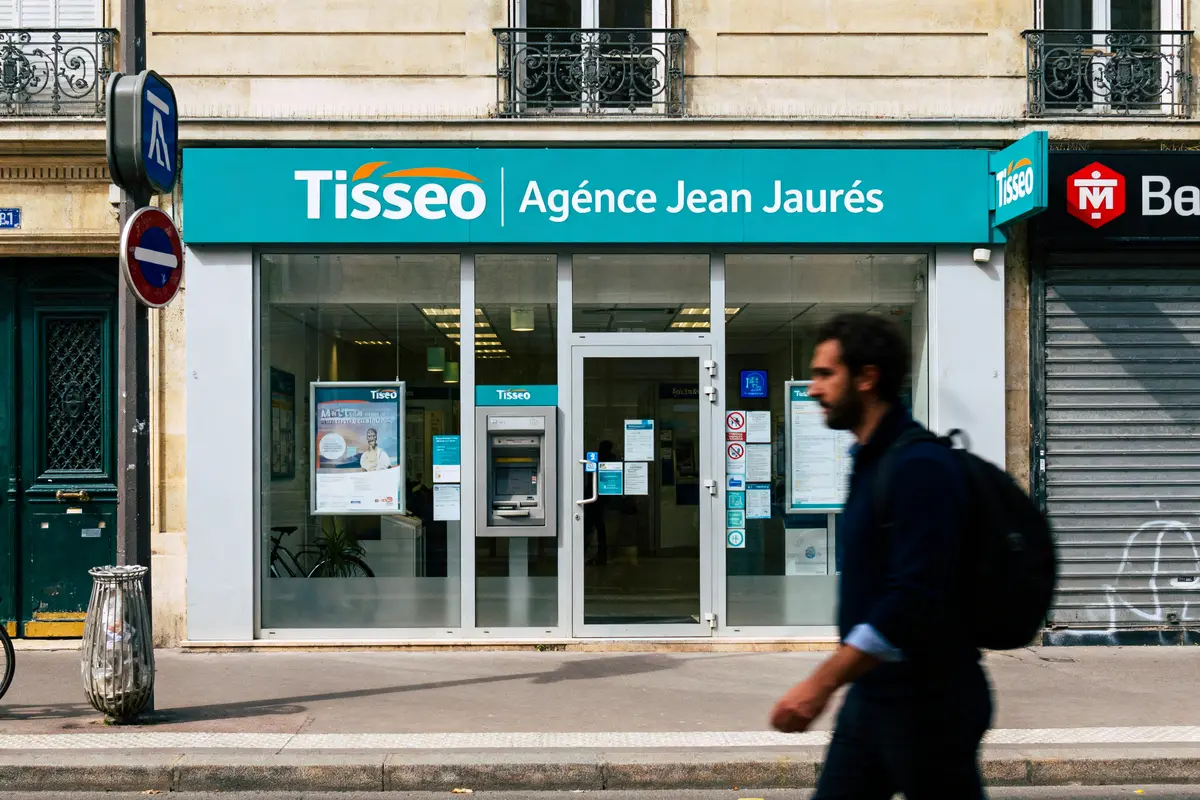 pexels-michal-pech-213601-757318 (1) Façade de l'agence Tisséo Jean Jaurès, piéton passant devant, jour ensoleillé.