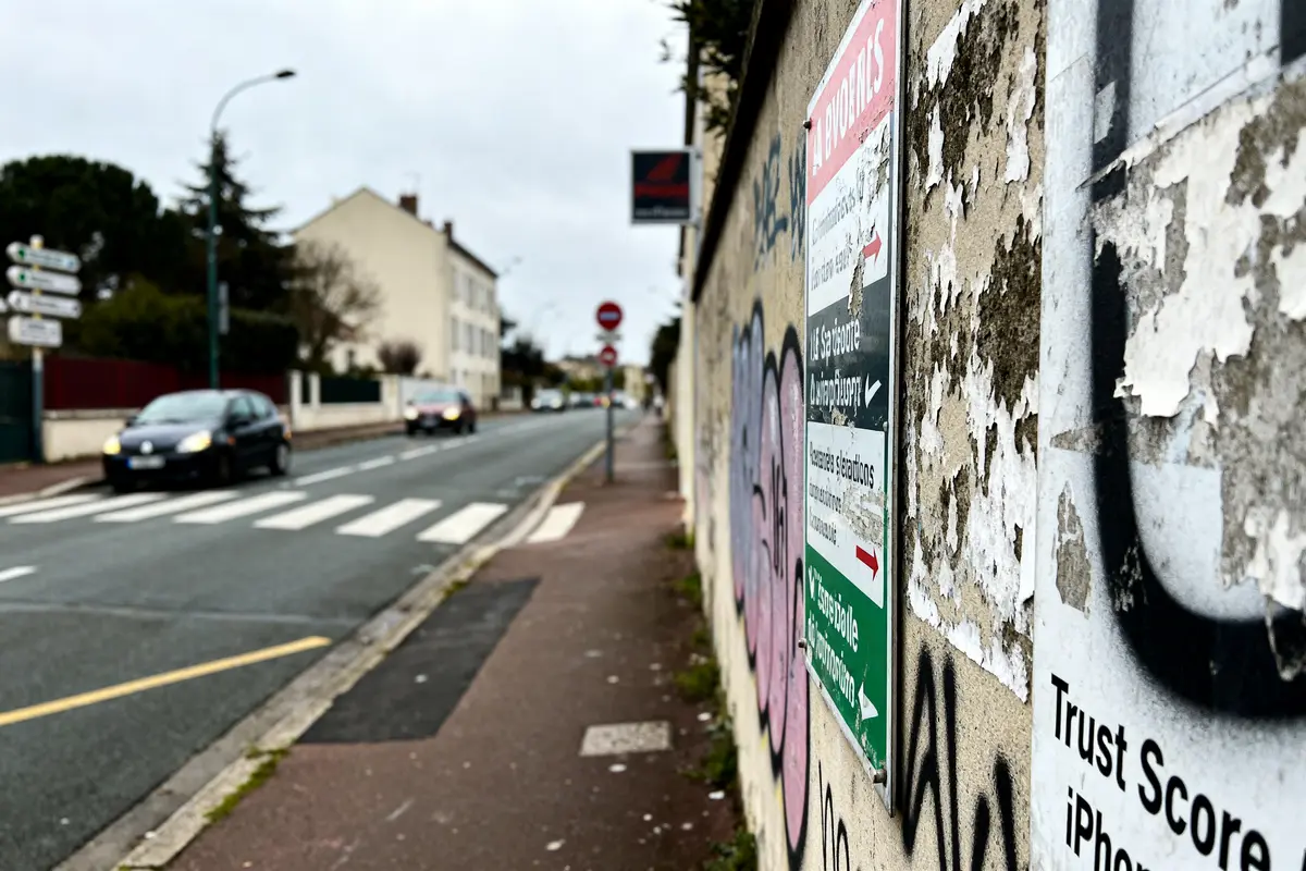 pexels-michal-pech-213601-757318 (1) Wall with Clematore graffiti, faded posters, and street view of cars and buildings